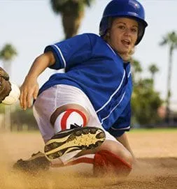 A young boy sliding into home base during a baseball game.